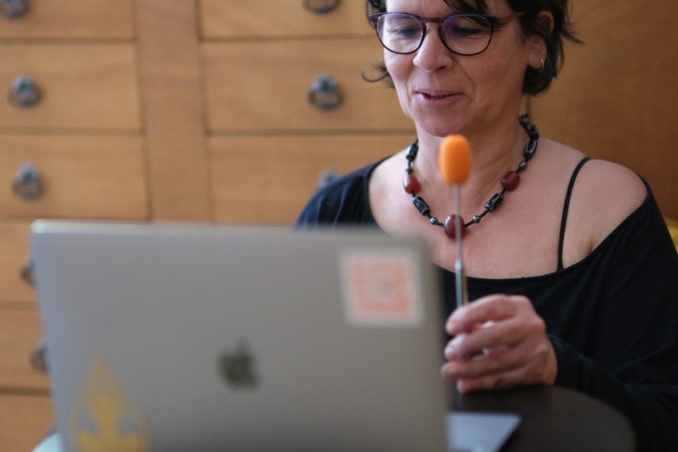 Raquel Devillé tenant un pointeur de Brainspotting devant son écran, pendant une séance à distance